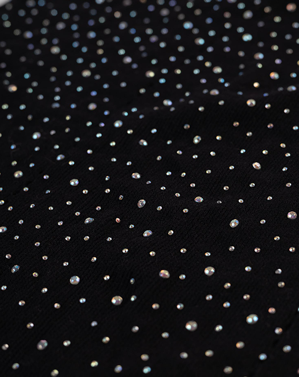 Krupni plan crne tkanine sa malim srebrnim cirkonima.