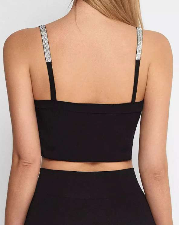 Model u topu sa sjajnim bretelama. Slika iza leđa.