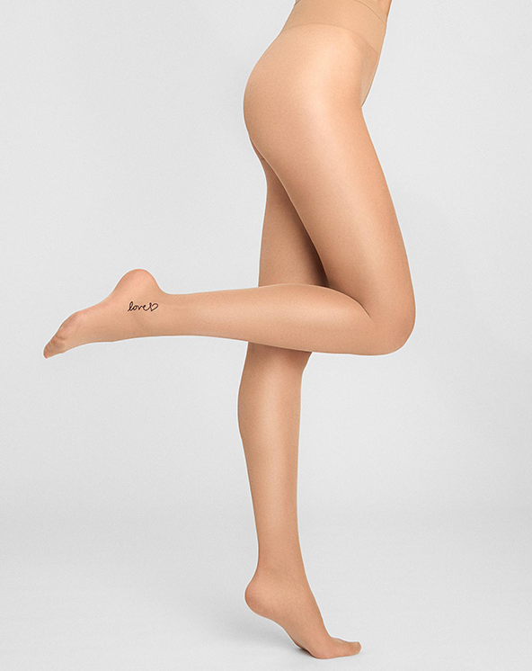 Bež unihop čarape sa natpisom love, nošene na svetlo sivoj pozadini.
