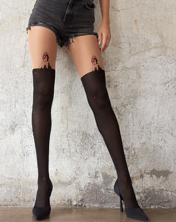 Model koja nosi crne čarape do butina sa teksturiranom pozadinom zida.